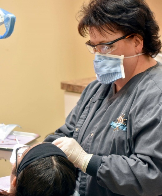 Dental team member treating dental patient