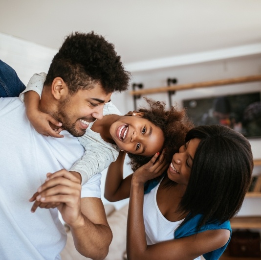 Family smiling together after visiting their dentist