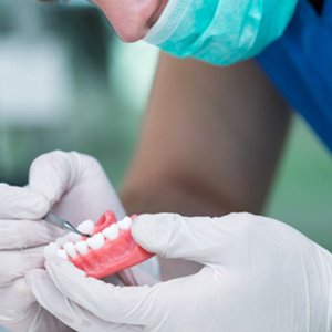 A dental worker crafting a denture
