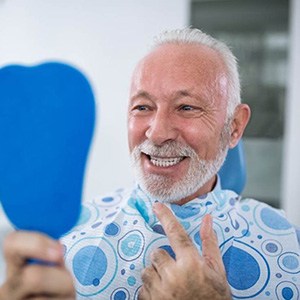 a patient checking their new tooth replacement in the mirror