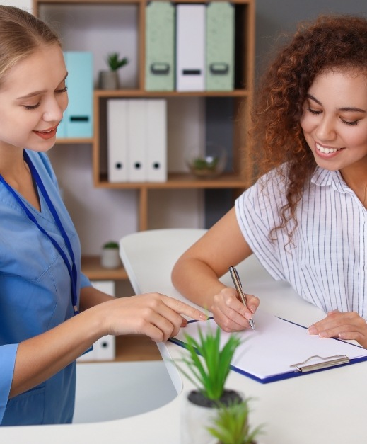 Dental team member and patient reviewing the cost of dental emergencies