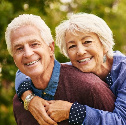 Man and woman with healthy smiles after restorative dentistry