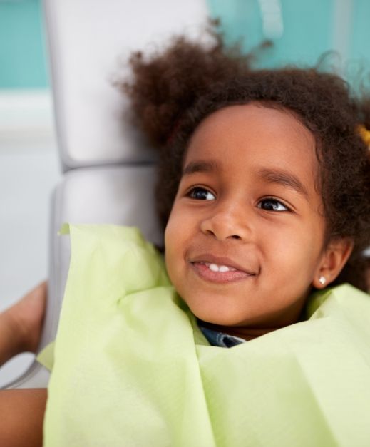 Young girl smiling during dental checkup and teeth cleaning visit
