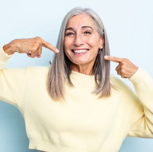 Mature woman pointing at her confident smile