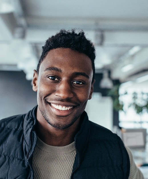 Man in vest smiling in an office