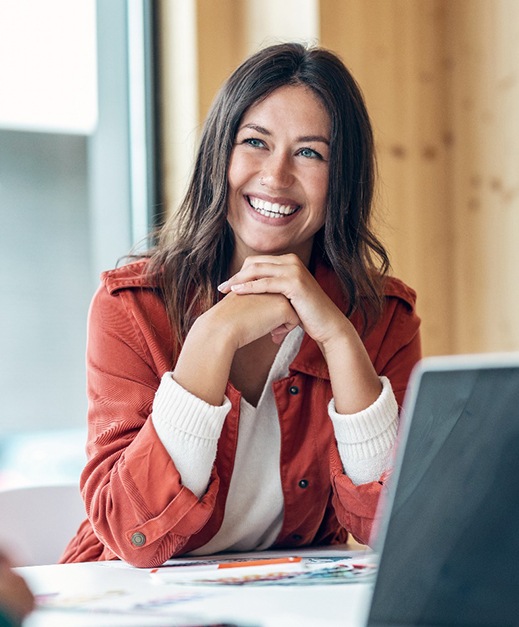 Woman sitting at her desk and smiling