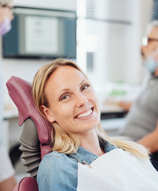 Happy, smiling dental patient in treatment chair