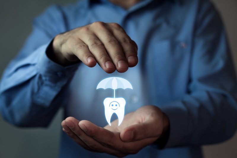 Man holding a hologram of a tooth with an umbrella