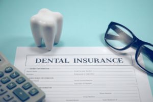 Calculator, molar, eyeglasses, and dental insurance form