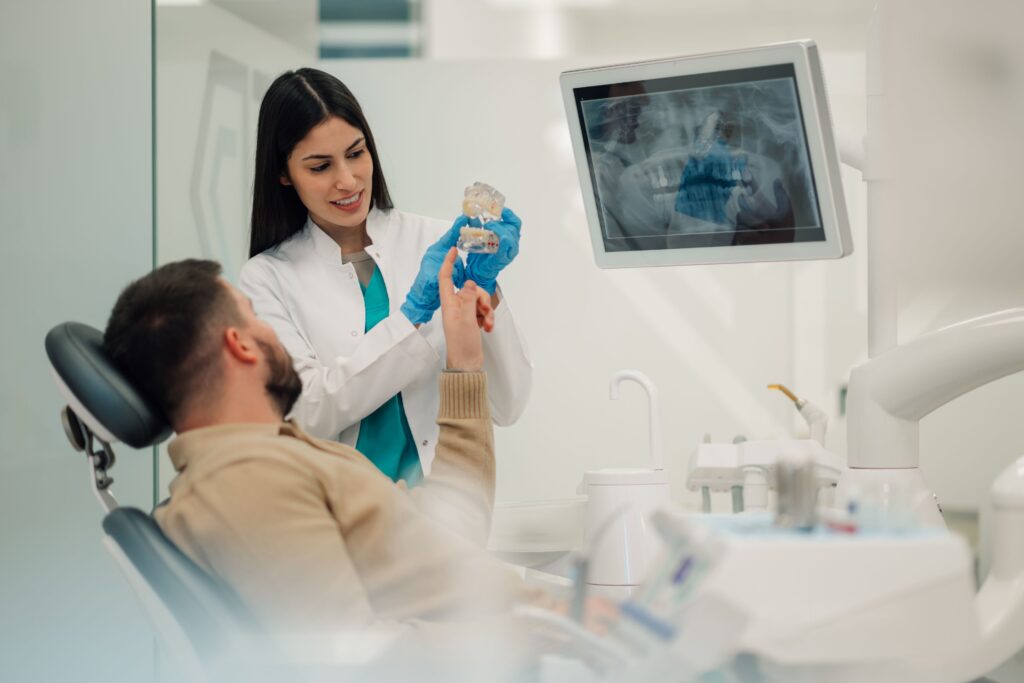 Dentist showing patient his X-rays and model teeth