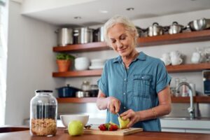 Older woman cutting an apple into smaller pieces